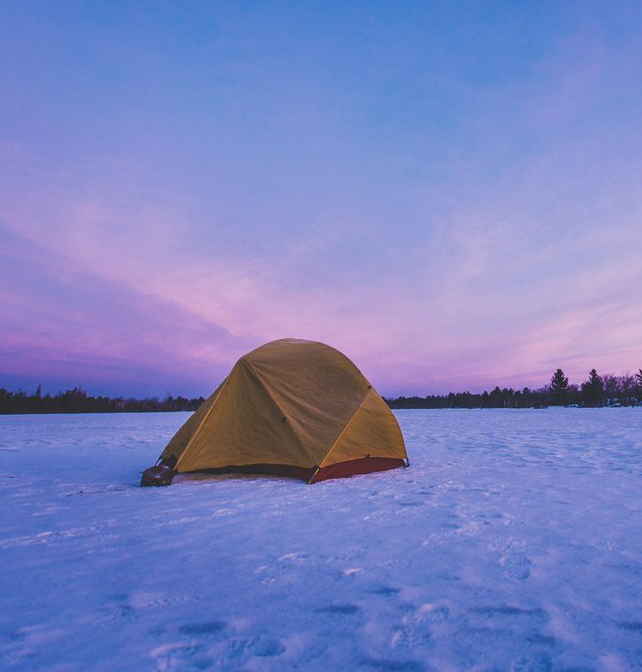 Winter camping image of a tent on snow with pink and blue sky. Image credit to DESTINATION ONTARIO 