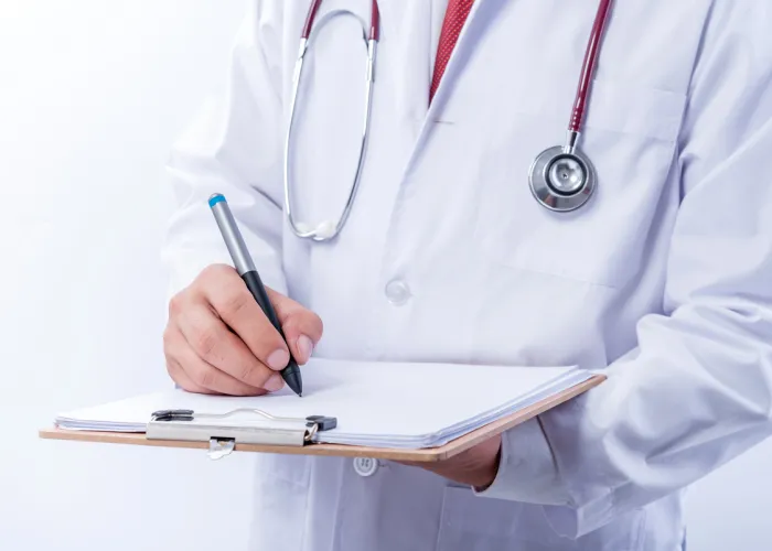 physician writing on paper pad