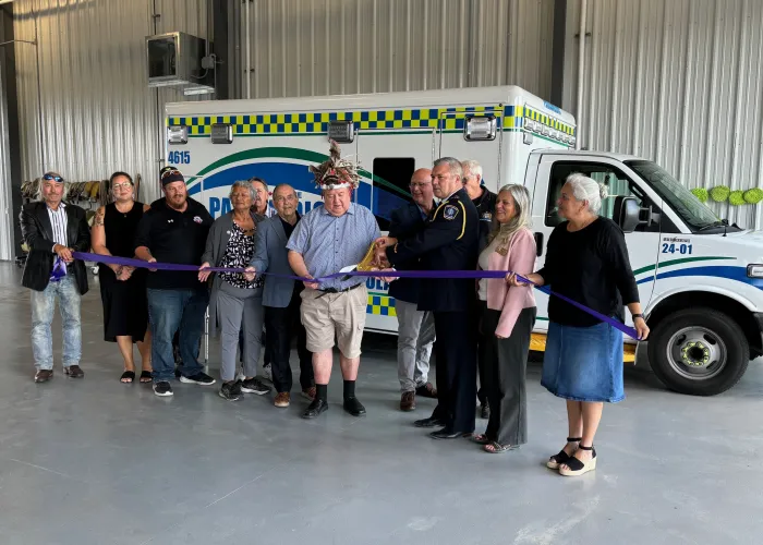 Ribbon cutting in front of ambulance