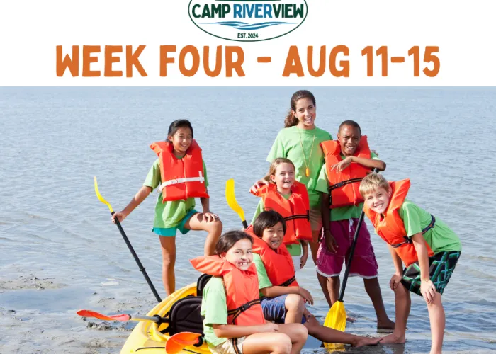 photo of kids in the water standing and sitting around a kayak with lifejackets on