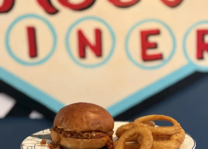 Photo of onion rings and sandwich on a plate