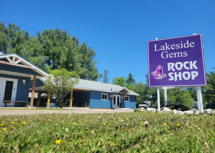 Photo of the outside of the lakeside gems building (blue) and their purple billboard