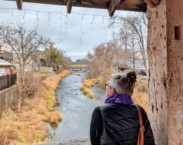 Woman leaning over railing of covered bridge at the river in Stirling